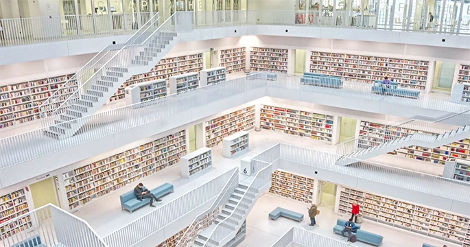 Große, helle Bibliothek mit zahlreichen Regalen und Arbeitsplätzen, um das Konzept der Informationsorganisation und -recherche durch SL2inoxision zu veranschaulichen