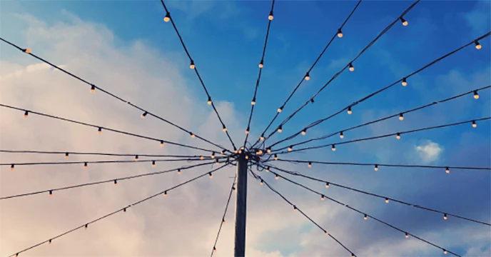 Zentraler Mast mit sternförmig gespannten Kabeln gegen einen bewölkten Himmel, metaphorisch für die Vernetzung durch SyUnify EDI der Firma SyLinx GmbH.
