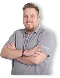 Der lächelnde Consultant der SelectLine Software GmbH Lars Landshuter verschränkt die Arme, trägt ein graues Poloshirt mit dem Firmenlogo und steht als Referent für individuelle Schulungen bereit.