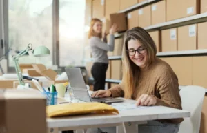 Frauen im Büro mit vielen Pakten im Hintergrund